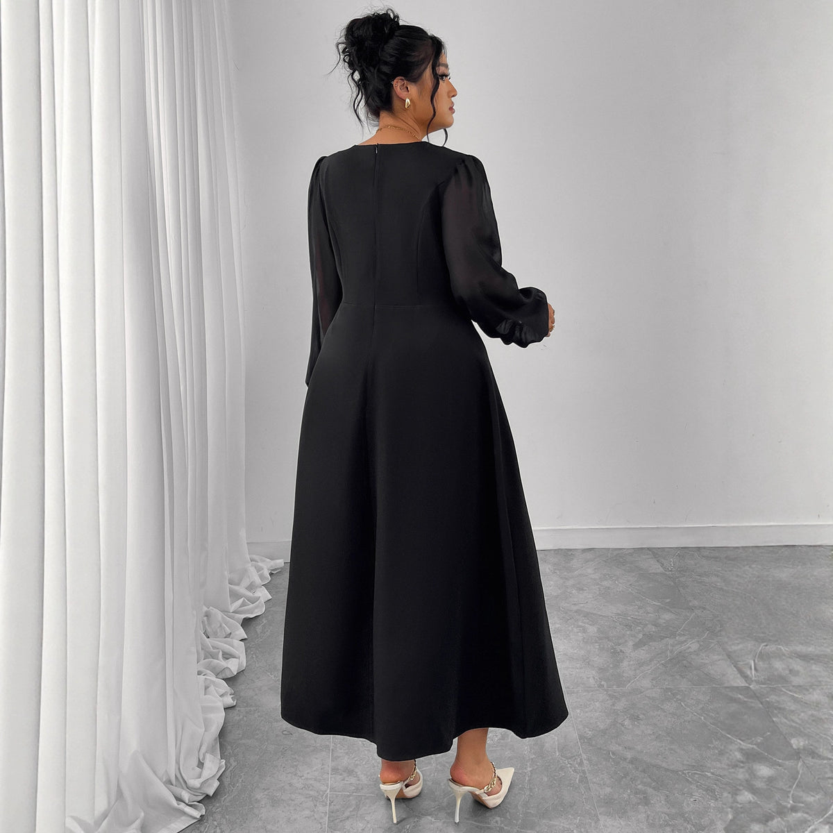 Black long-sleeve midi dress, back view with flowing pleated skirt