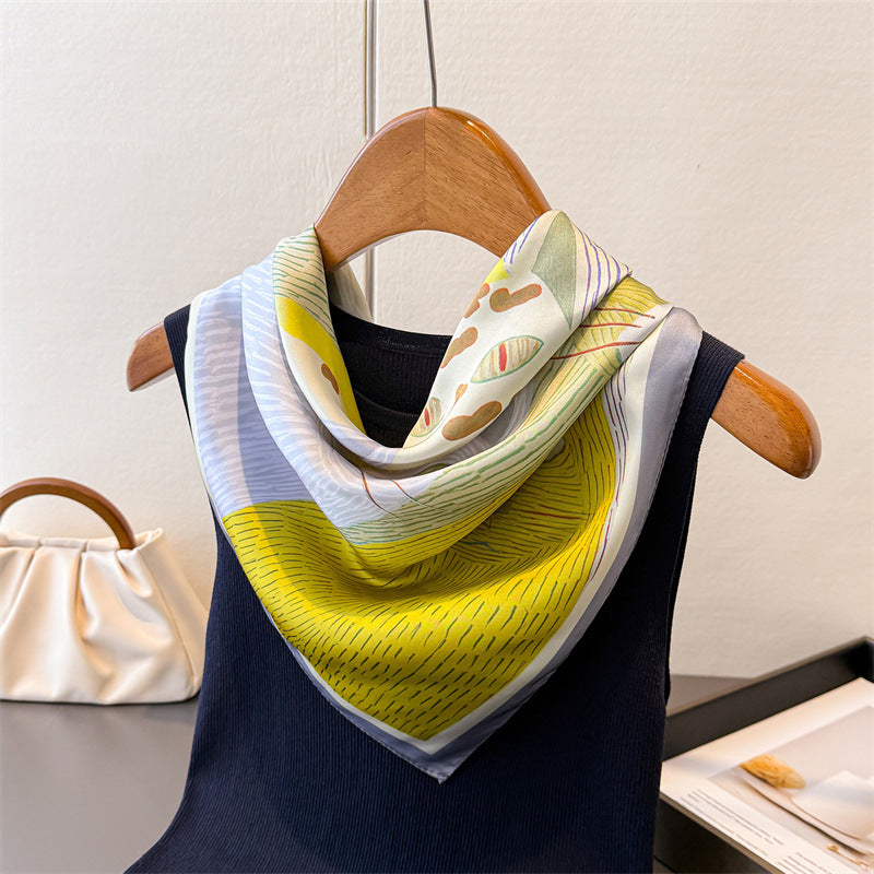 Cat-print silk-look square scarf draped on a hanger with yellow and pastel stripes