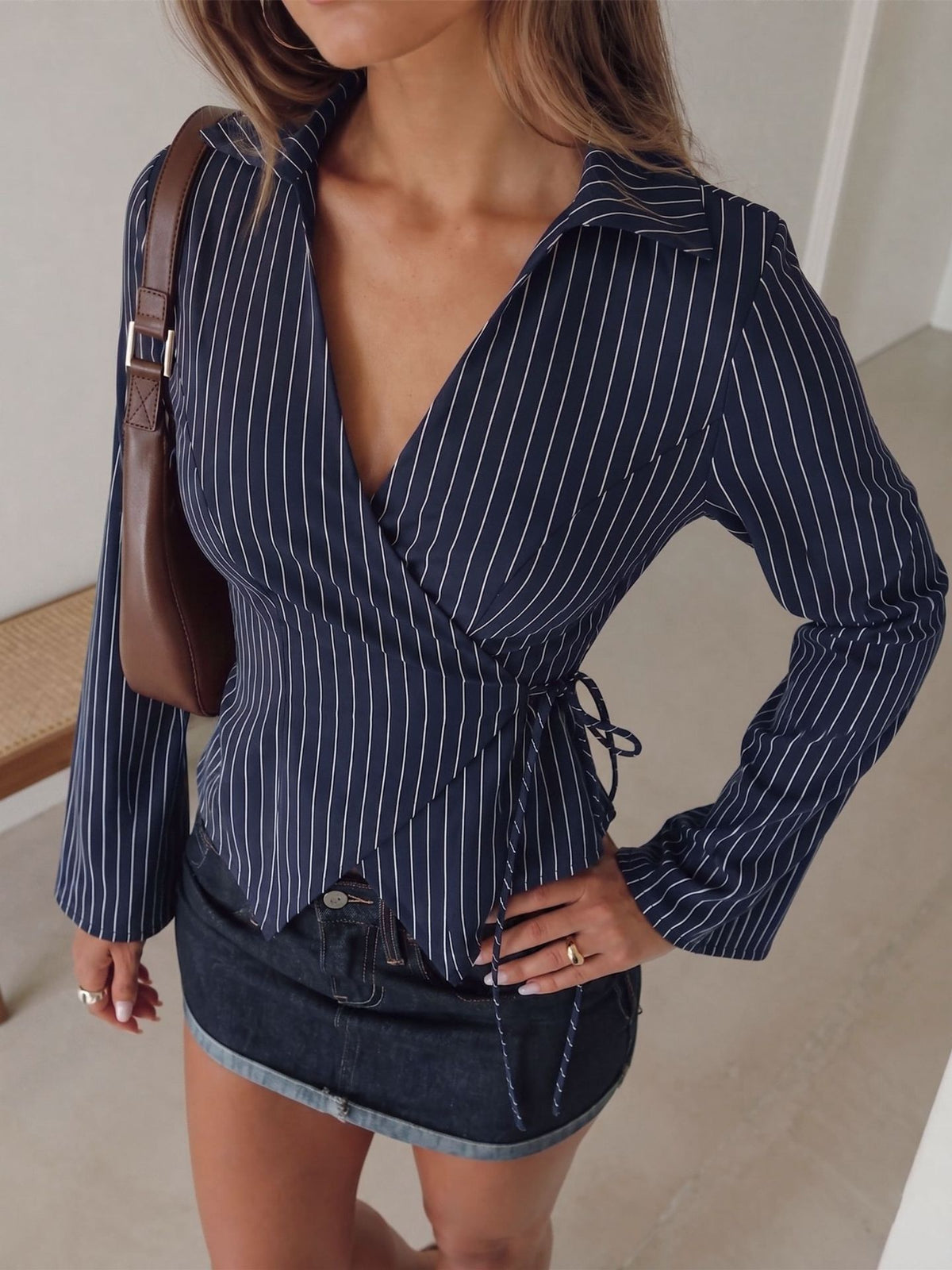 Navy pinstripe long-sleeve blouse with V-neck collar, tied waist, flared cuffs