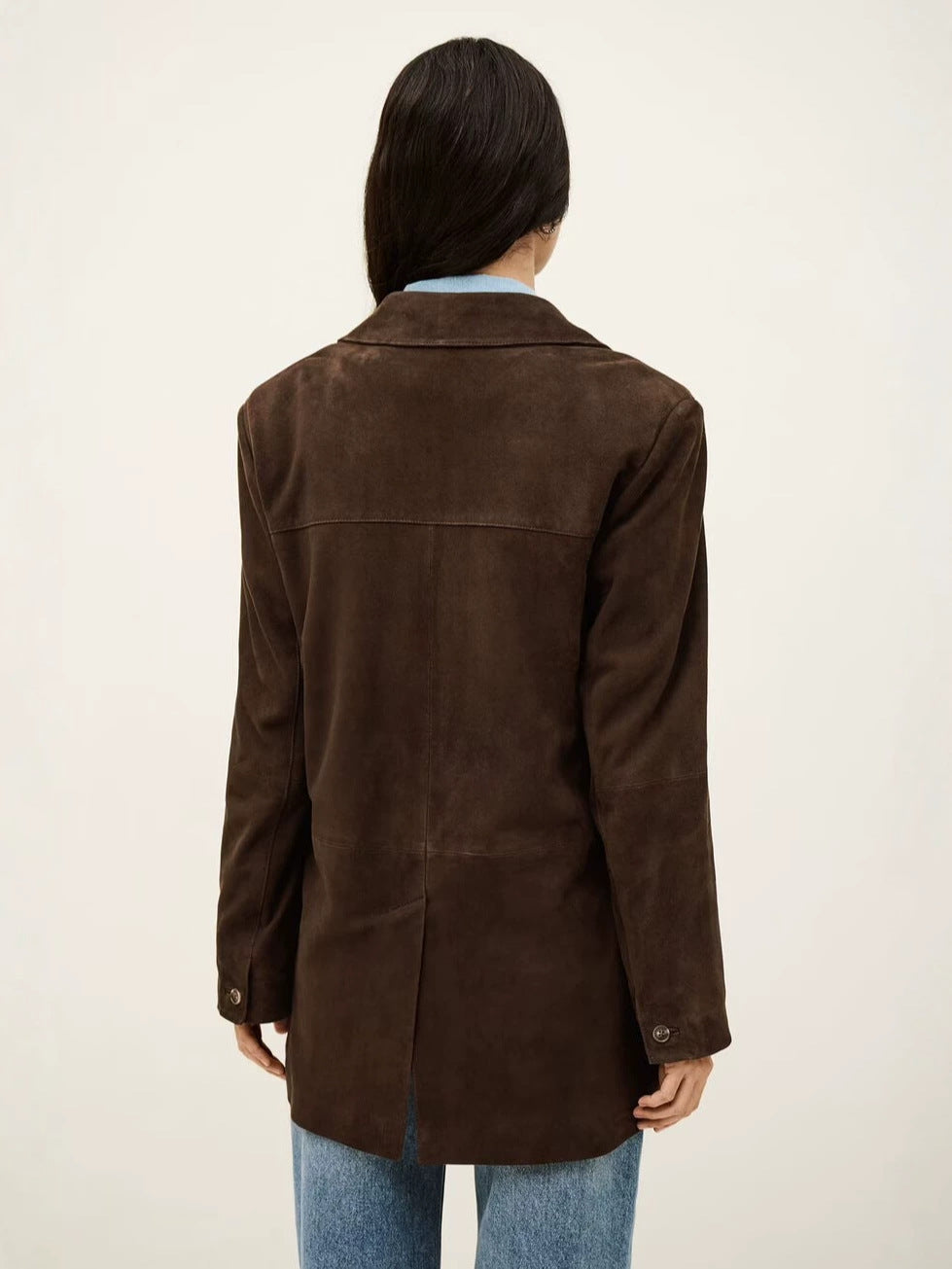Back of dark brown suede blazer showing seam details and a center vent