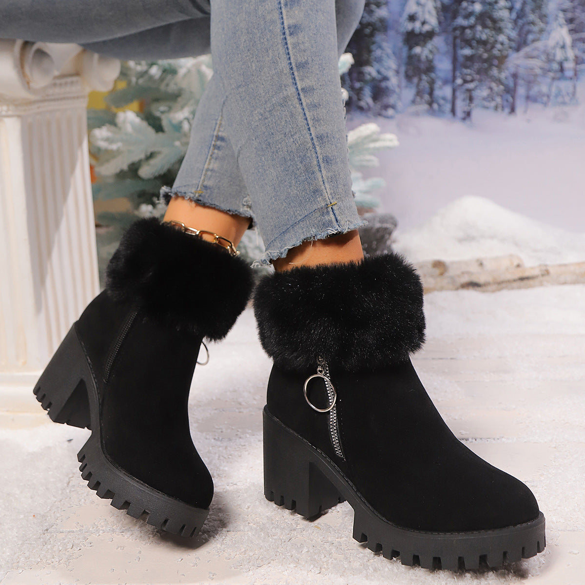 Black mid-calf snow boots with faux fur top, thick block heel, side zipper and ring pull.