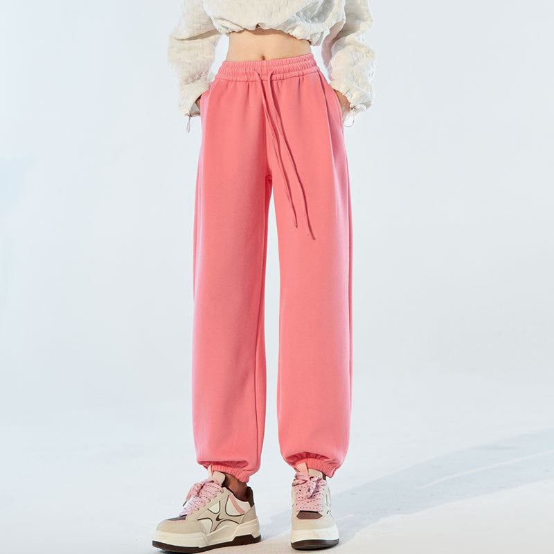 Pink high-waist jogger sweatpants with drawstring and gathered elastic cuffs.