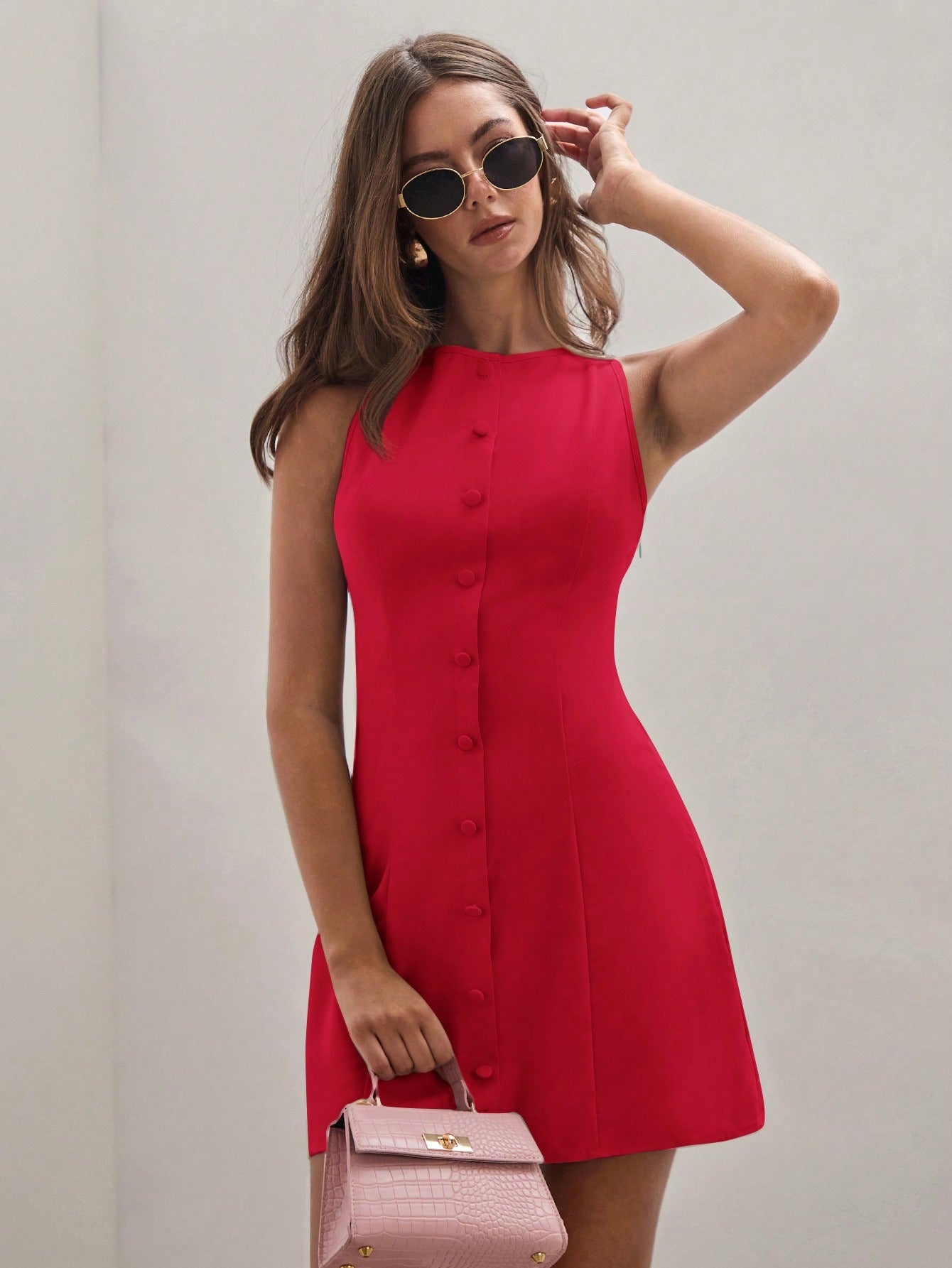 Red sleeveless shift dress with round neck and button-front mini hem
