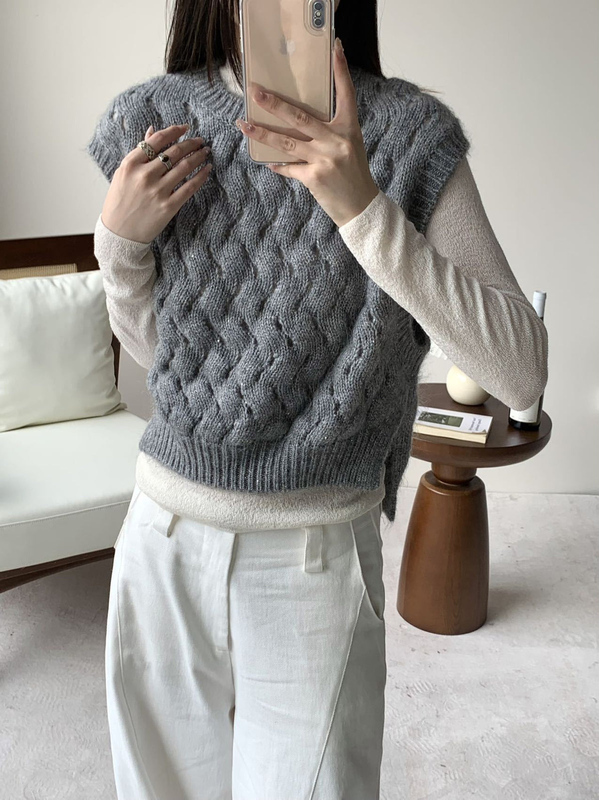 Gray chunky cable-knit sweater vest with sleeveless crew neck and ribbed hem