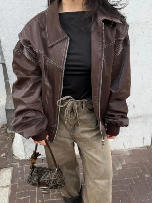 Brown faux leather moto jacket with contrast seams, front zip, relaxed cropped silhouette
