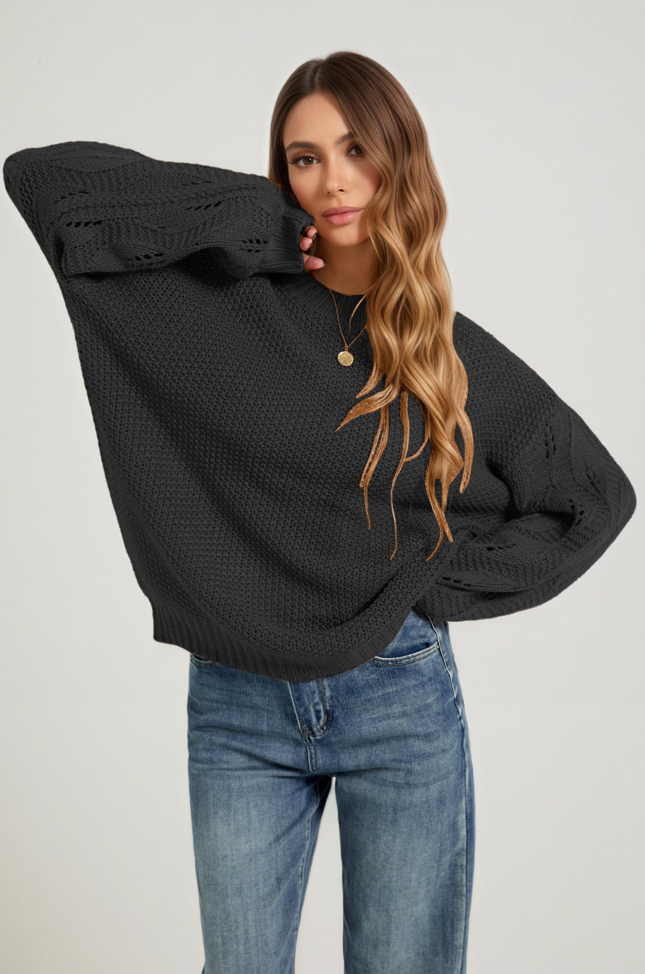 Black open-stitch sweater with long sleeves and round neckline, front view