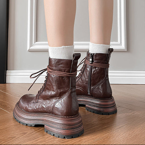 Brown lace-up ankle combat boots, showing heel platform and treaded sole