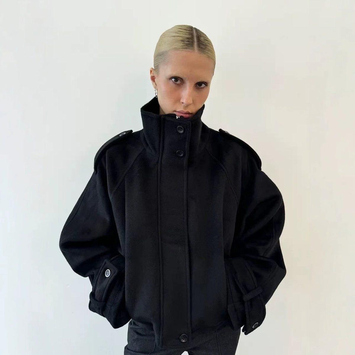 Black wool jacket with stand-up collar and snap buttons, loose casual fit.