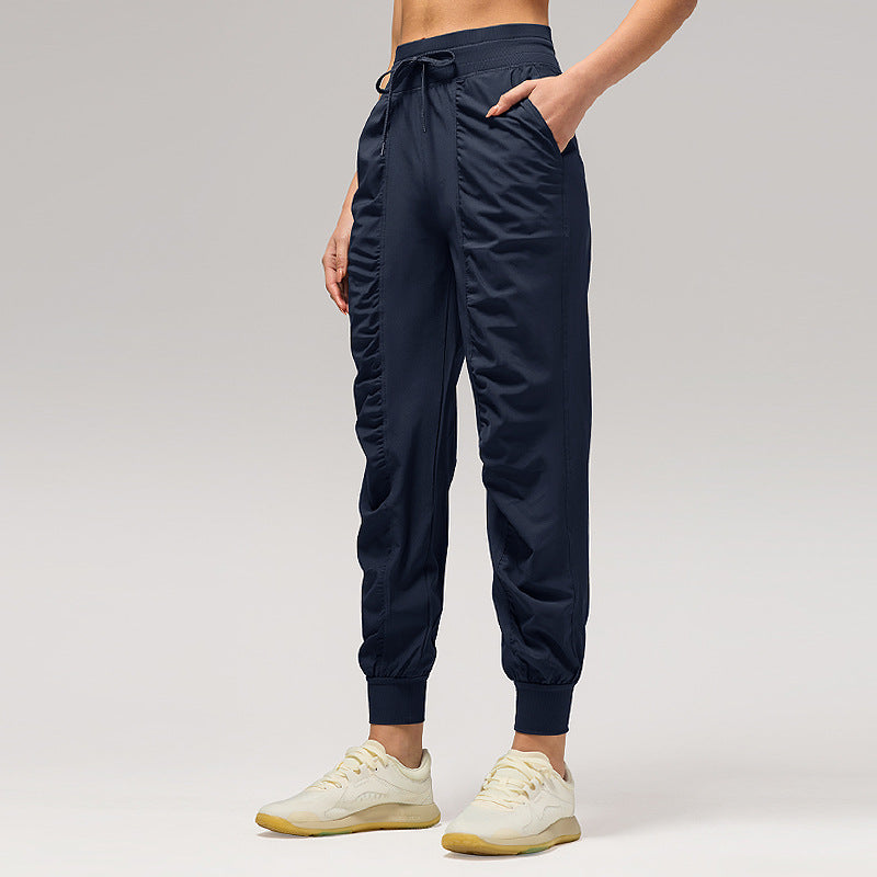 Women’s loose navy jogger pants with drawstring waist and cuffed ankles, side pockets.