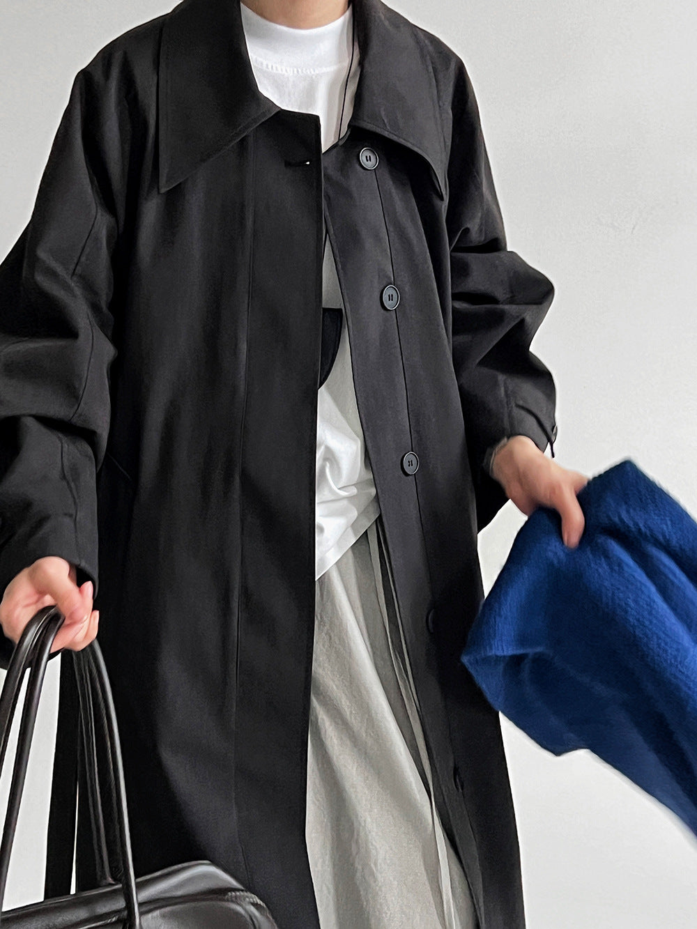 Women’s black lapel trench coat with button placket and tie-waist belt