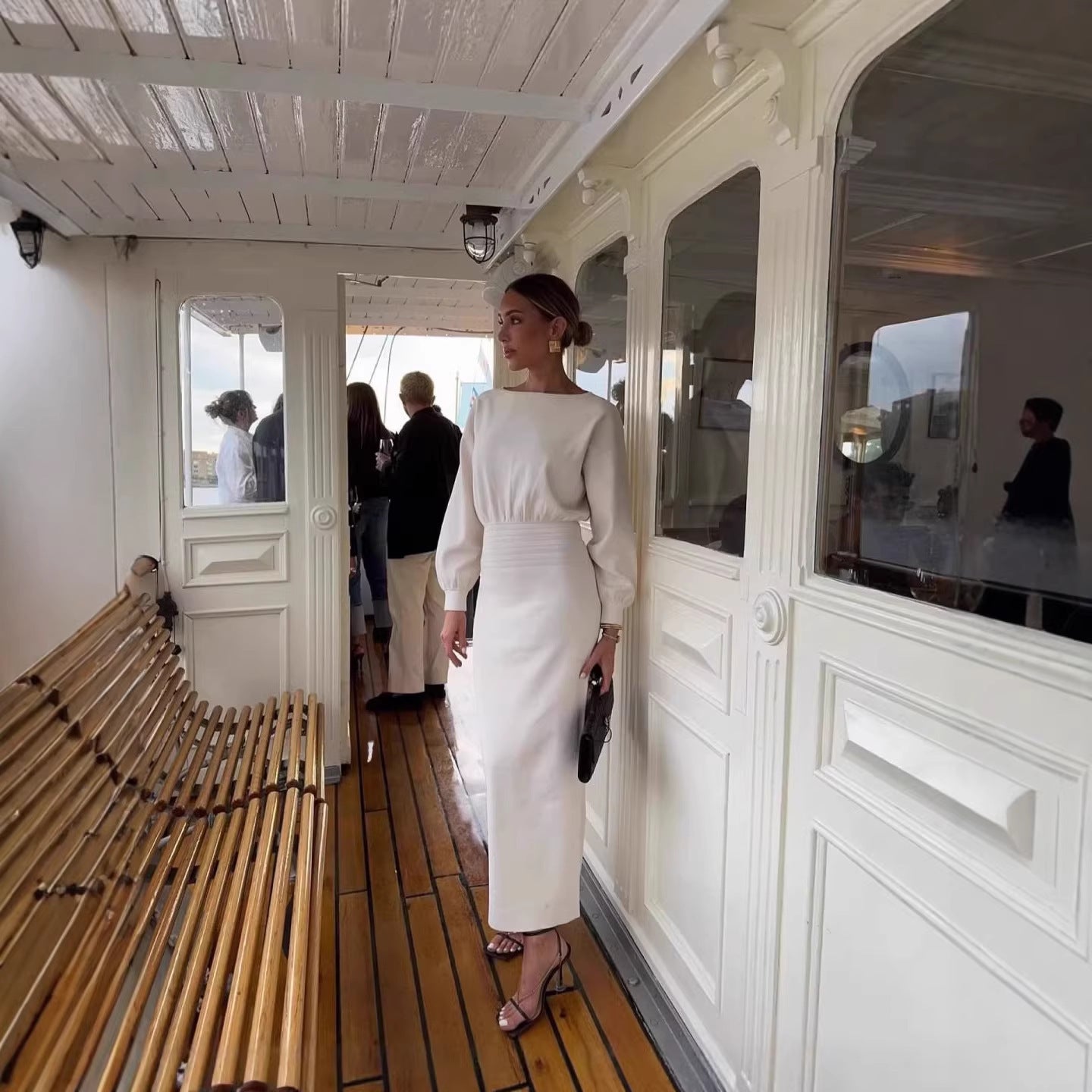 White fitted midi dress with long puff sleeves and cinched waist, side view