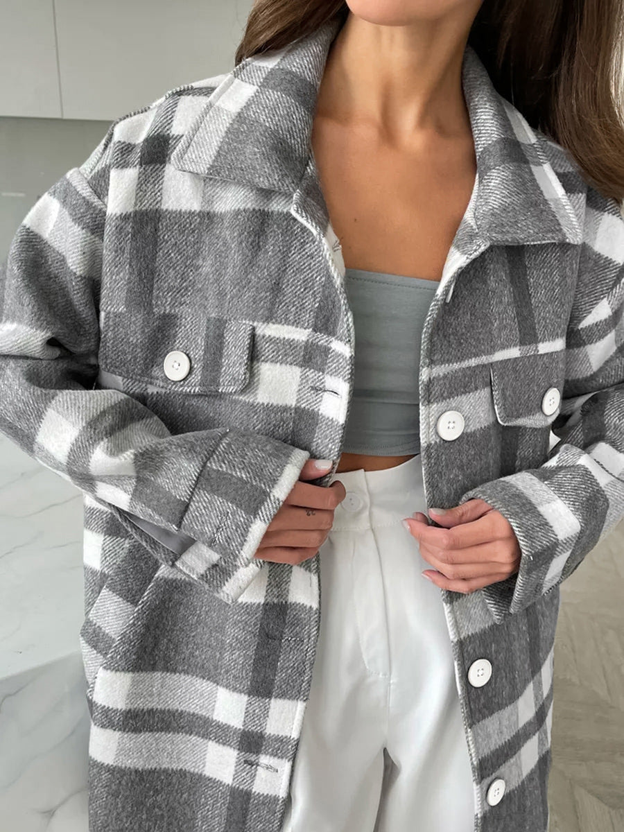 Close view of gray plaid coat lapels, white buttons, and flap chest pockets