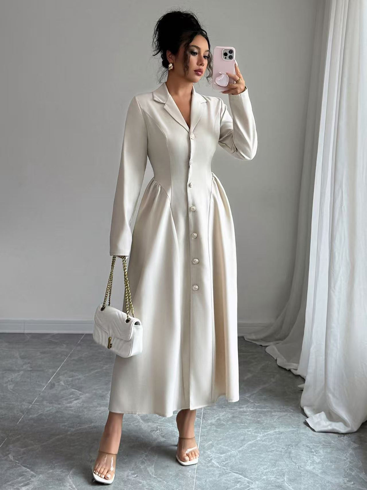 Off-white V-neck long-sleeve button-front dress with tailored waist, over-the-knee length