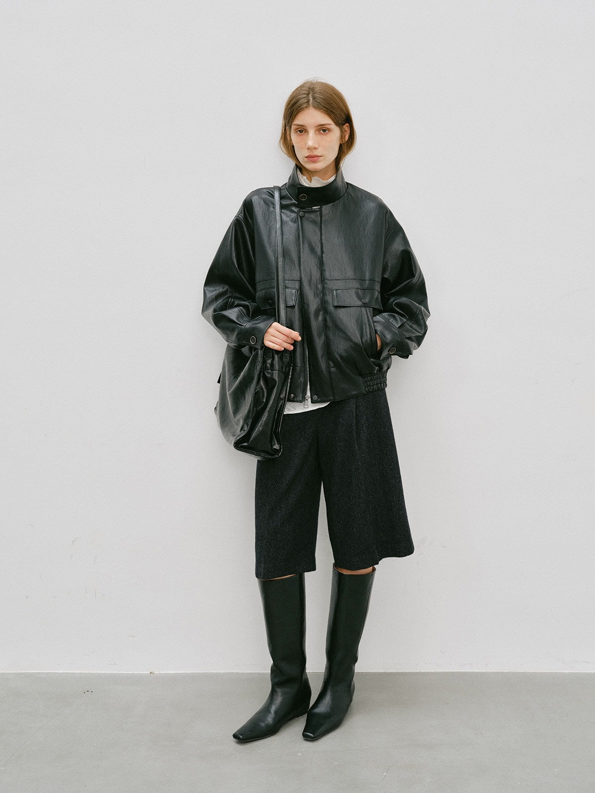 Black PU leather short jacket with stand-up collar and flap pockets, relaxed fit