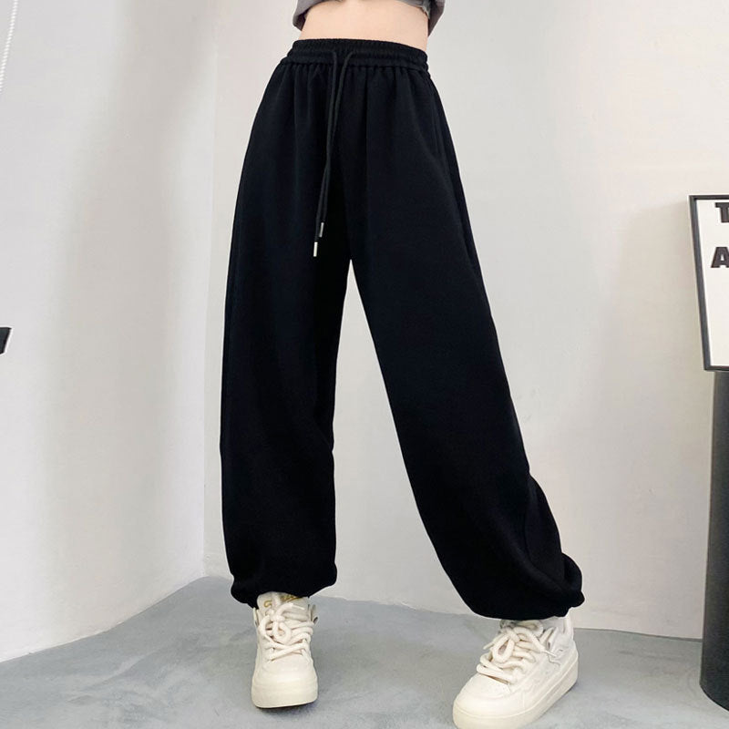 Black high-waist harem jogger pants with elastic waistband, drawstring, and loose fit.
