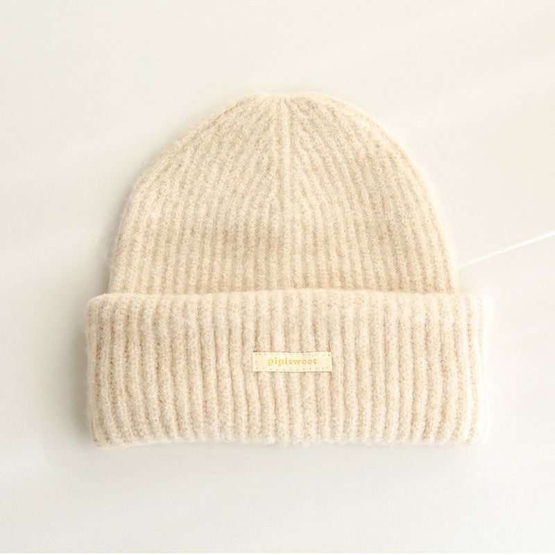 Cream ribbed knit beanie hat with cuff brim and pipiswoot logo patch