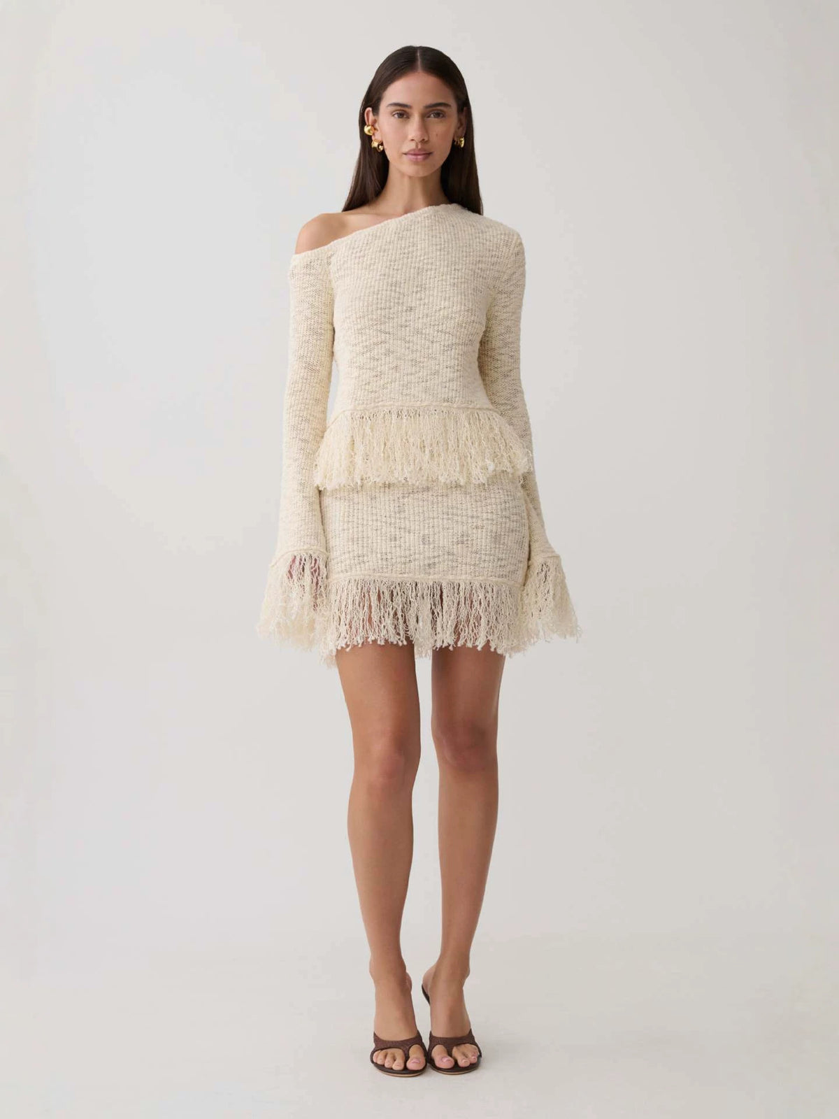 Apricot textured knit off-shoulder top with long sleeves and layered fringe hem, full length