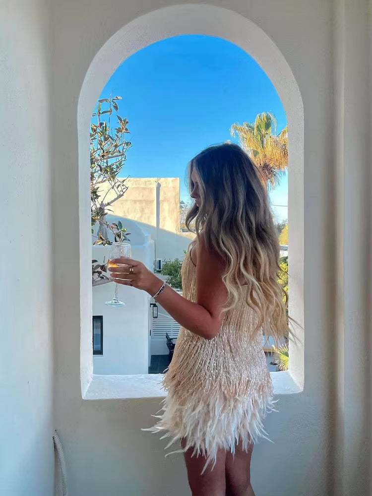 White v-neck mini dress with layered crystal tassel fringe and feather hem, side view