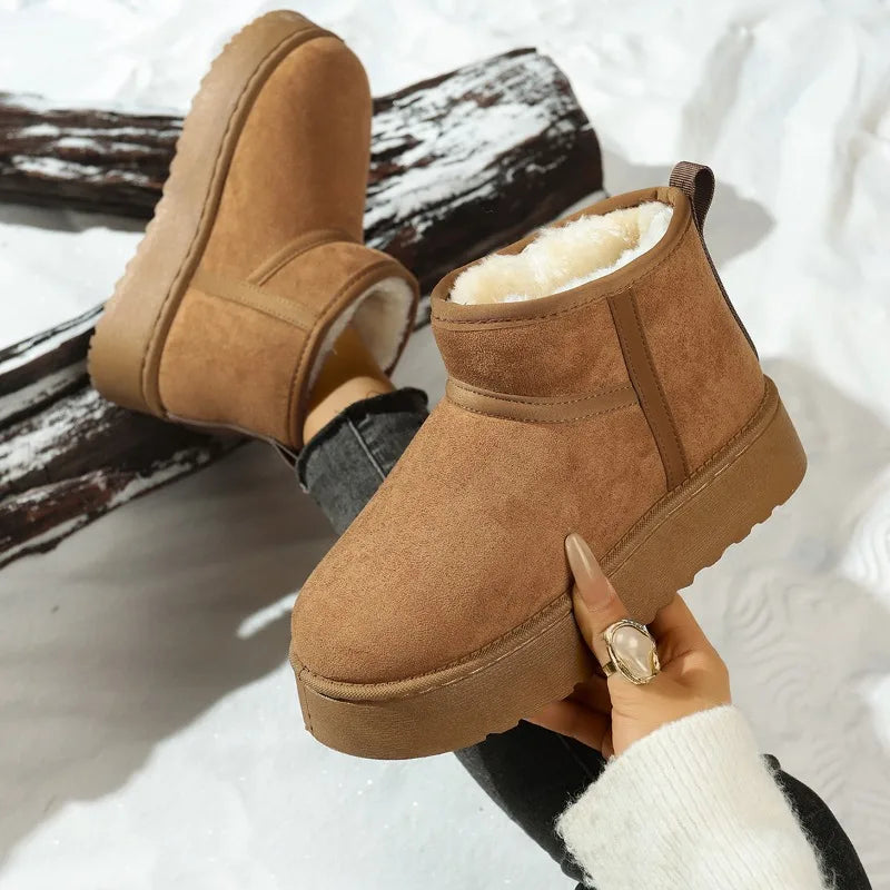 Tan suede fleece-lined ankle boot shown in hand, with matching boot worn behind