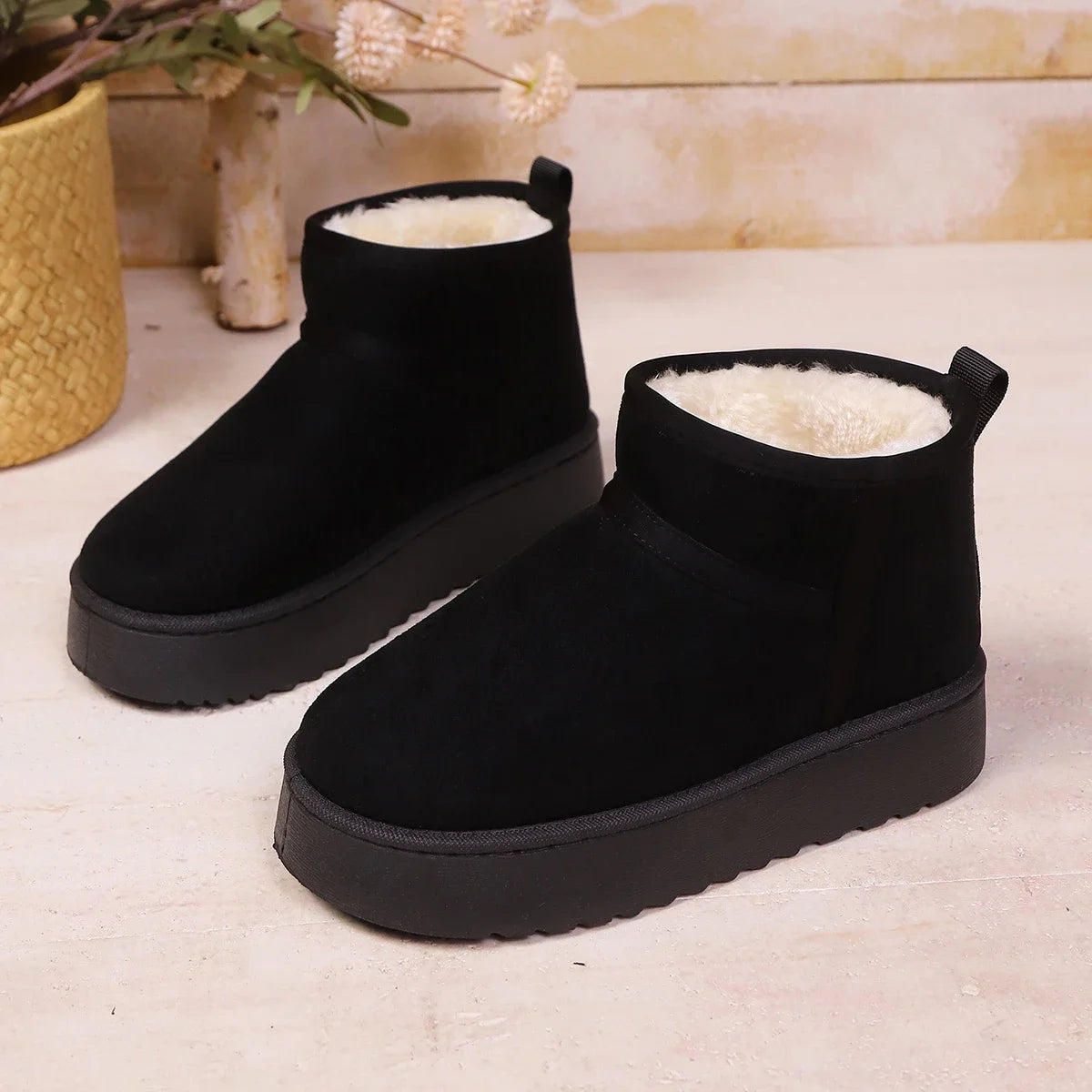 Pair of black suede ankle boots with cream fleece lining and thick soles