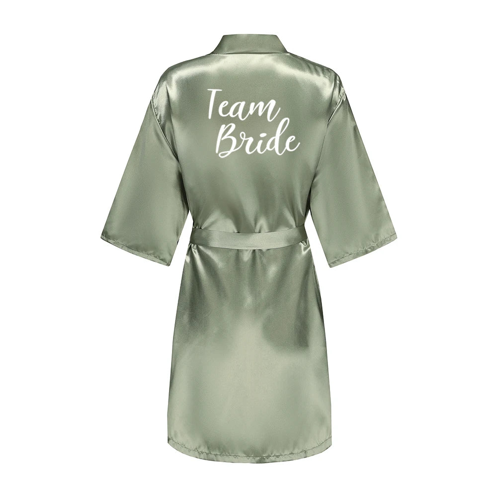 Sage green satin robe with short sleeves, waist tie, and white Team Bride lettering