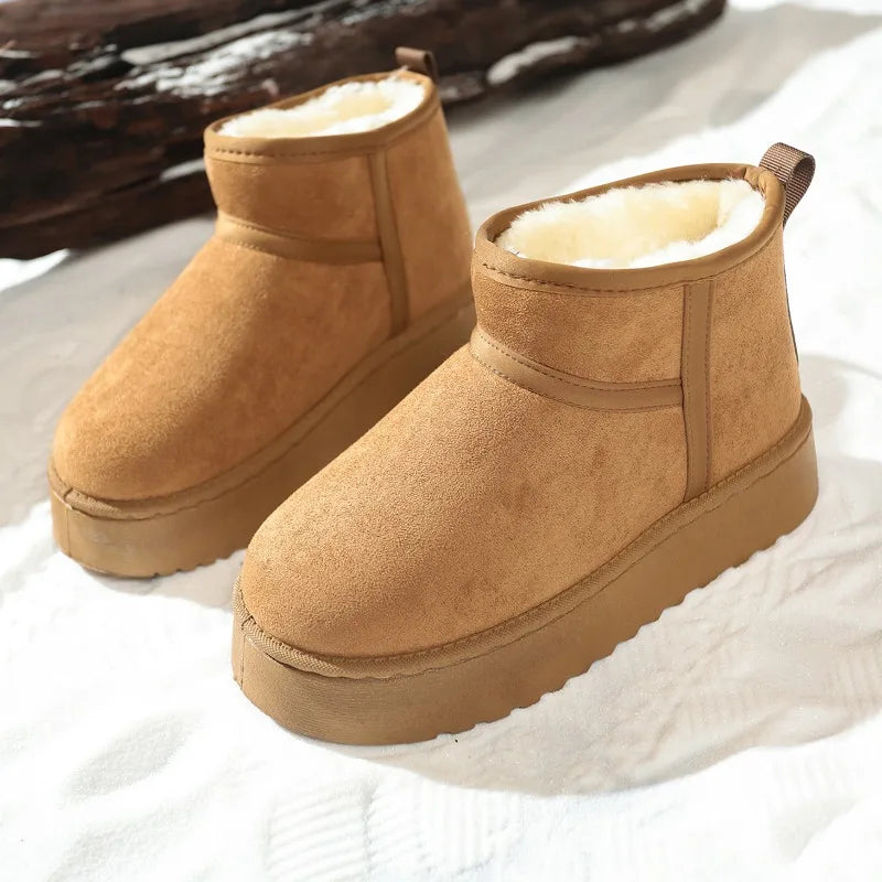 Pair of tan suede ankle boots with cream fleece lining and thick soles