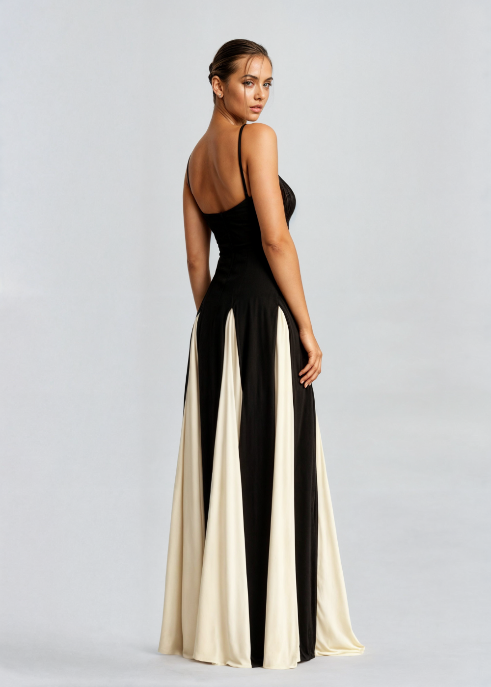 Side view of black satin maxi dress with spaghetti straps and vertical cream colorblock panels