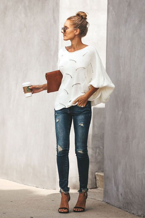 White oversized knit sweater with bat-wing sleeves and arched stitched motif