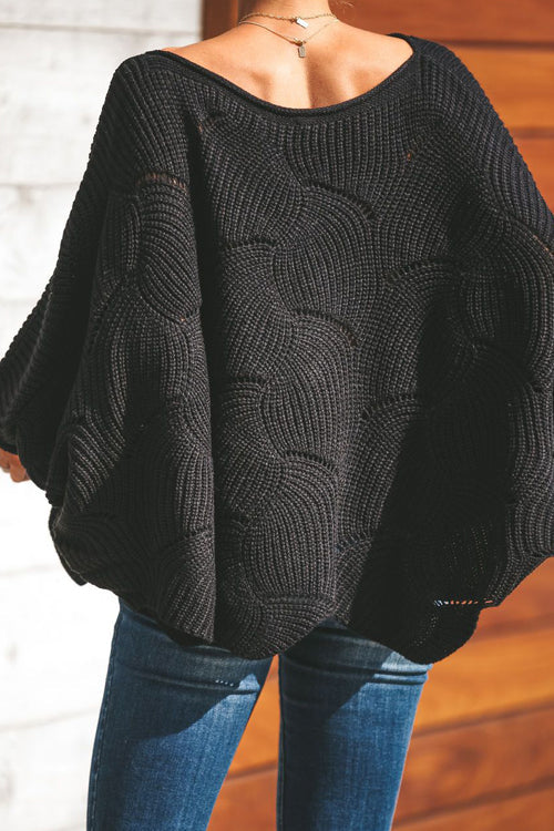 Black oversized knit sweater with wide bat-wing sleeves and spiral knit pattern