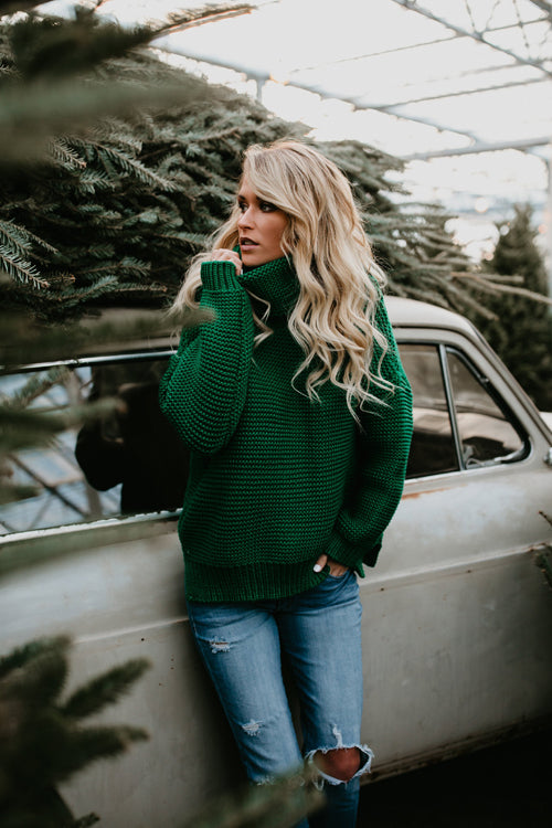 Green knit high-neck sweater with long sleeves and ribbed cuffs.