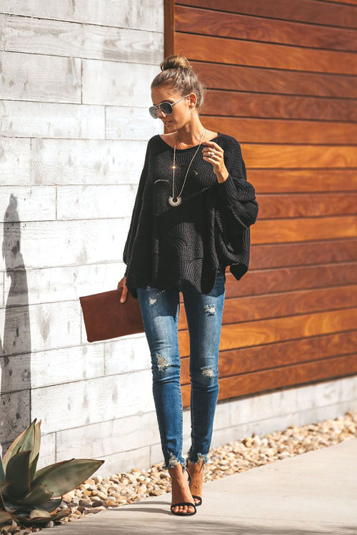 Black oversized knit sweater with bat-wing sleeves and curved stitched pattern