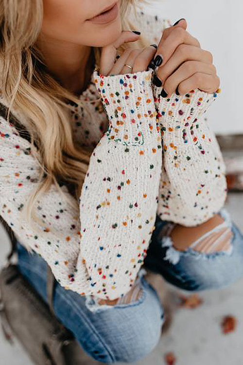 Beige knit sweater with colorful dot speckles, close-up of neckline and sleeve