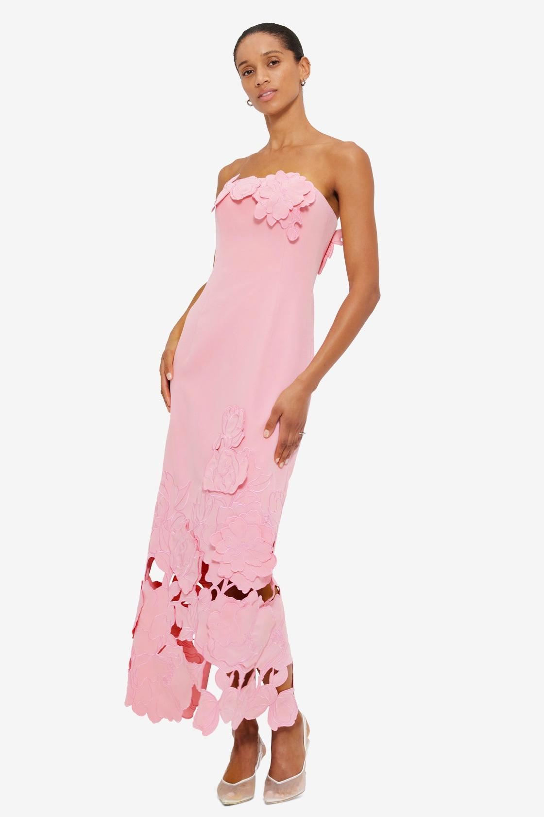 Strapless pink satin bodycon maxi dress with 3D floral appliqué and cutout hem