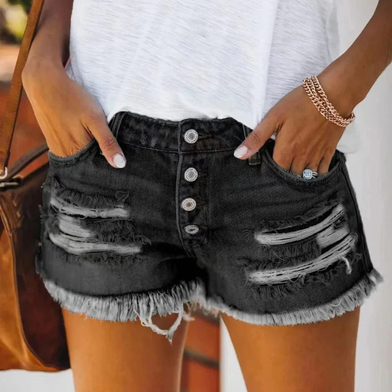Black denim button-fly shorts with distressed panels and frayed hem.