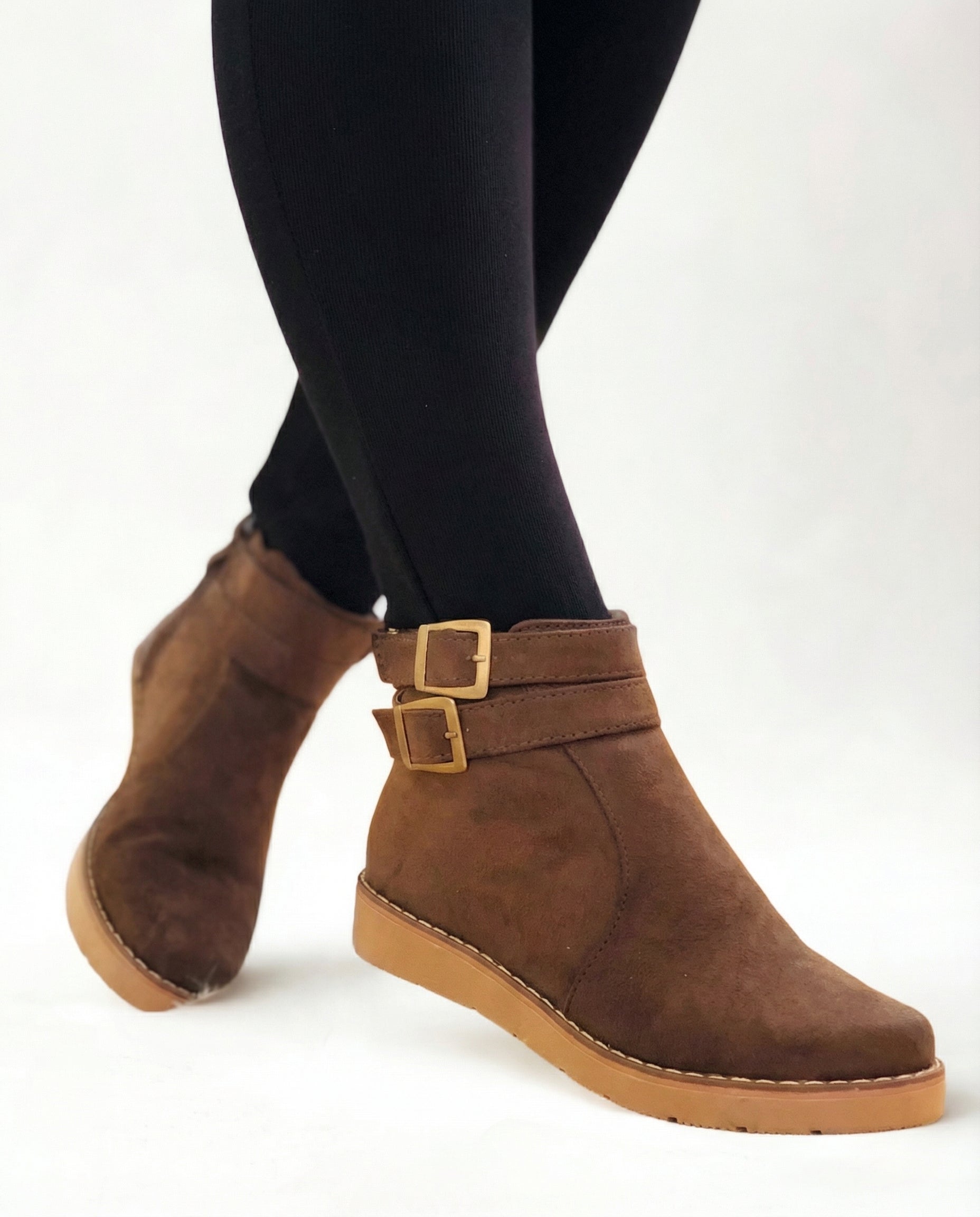 Brown suede ankle boots with double buckle strap and flat sole