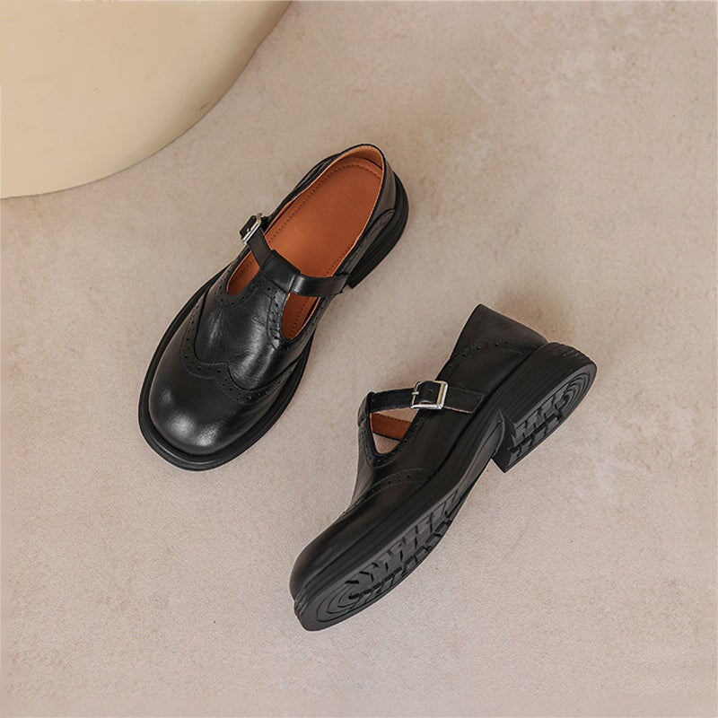 Black and brown leather Mary Jane flats with T-strap buckles and chunky lug soles.