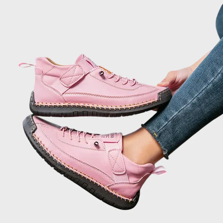 Pink faux leather lace-up sneakers with ankle strap and black rubber sole